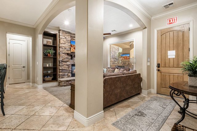 Tiled entry hall with front door and view into living room