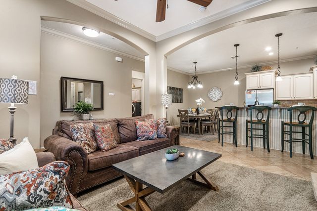 Living room opening to kitchen bar seating and dining area