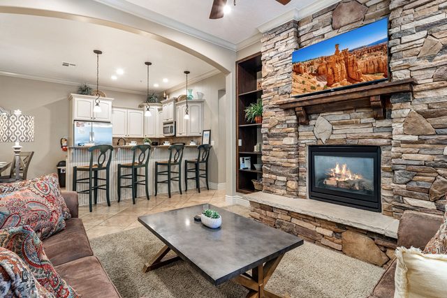 Stone fireplace and TV beside the kitchen breakfast bar
