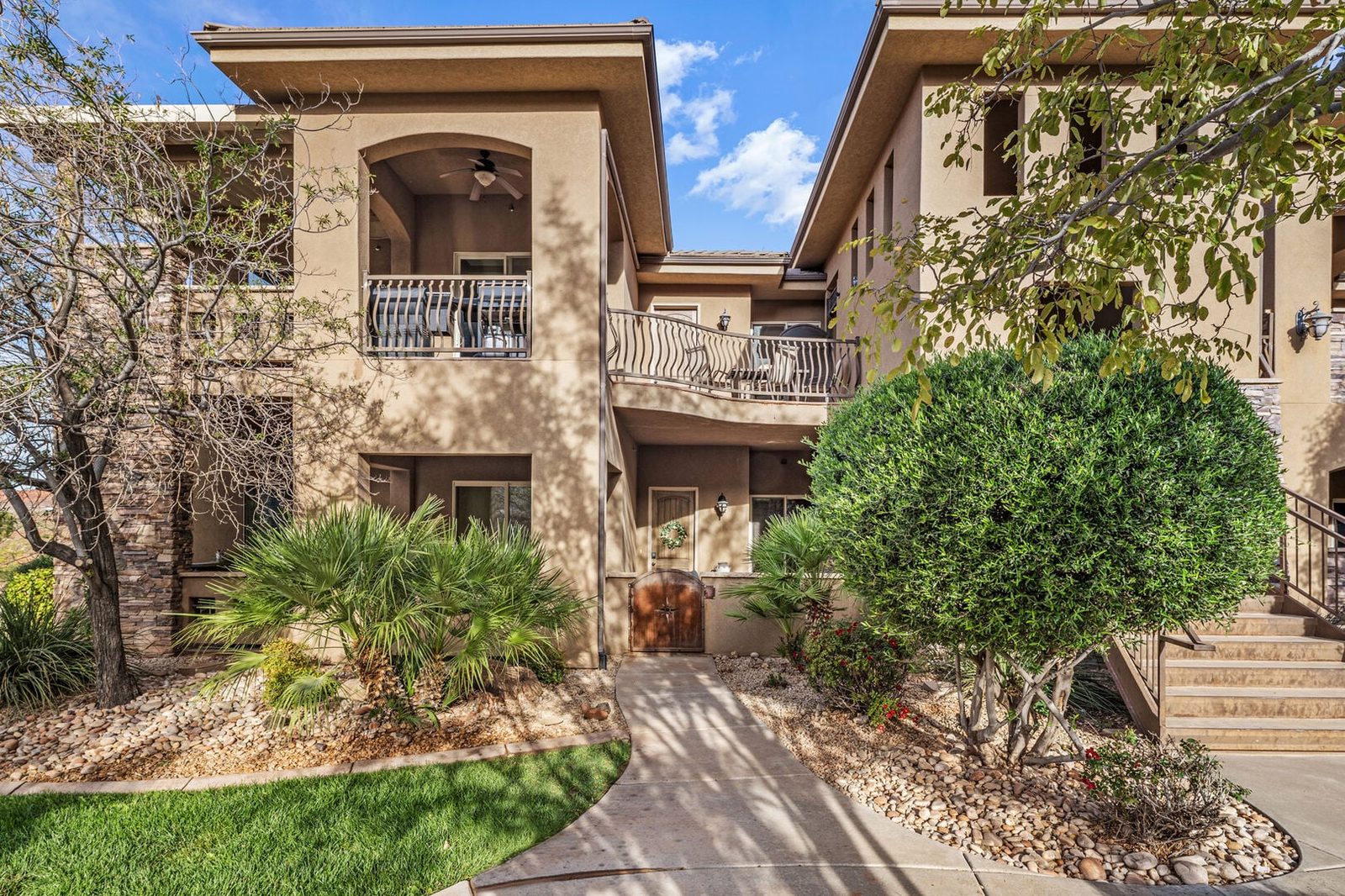 Stucco condo building exterior with landscaped walkway at Coral Springs D7