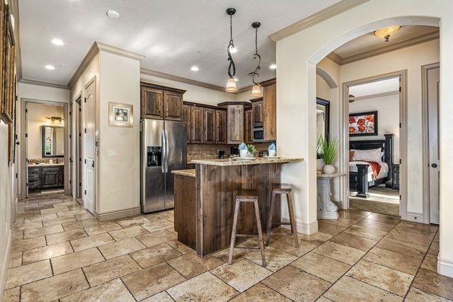 Kitchen with breakfast bar stools and stainless refrigerator