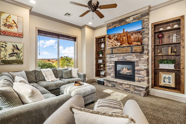 Sectional sofa facing stone fireplace with TV and built-in shelves