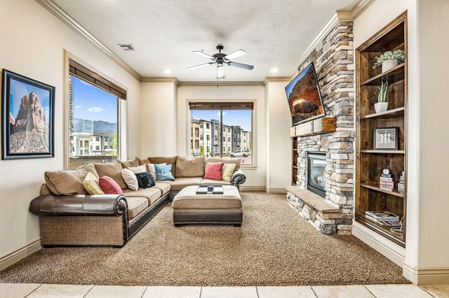 Living room sectional facing stone fireplace and wall TV