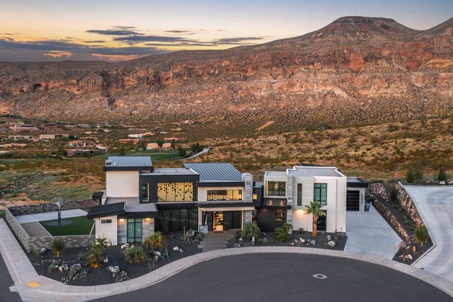 Aerial of the modern home on a cul-de-sac below red cliffs