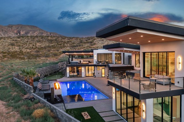 Twilight aerial of the home with pool and upper balcony
