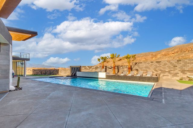 Long private pool with palm trees and desert hills