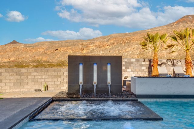 Hot tub with three waterfall spouts at the private pool edge