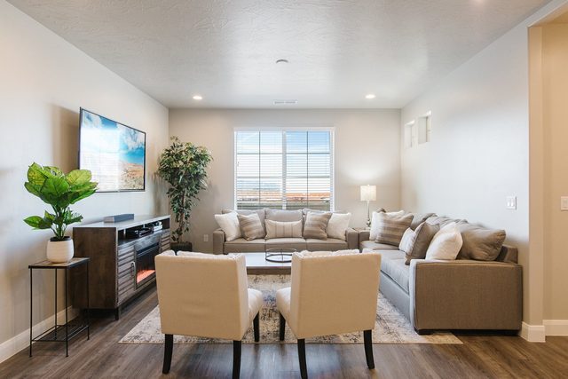 Living room with sectional, accent chairs and fireplace TV console