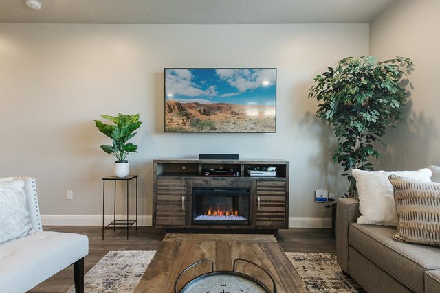 Electric fireplace media console below a smart TV