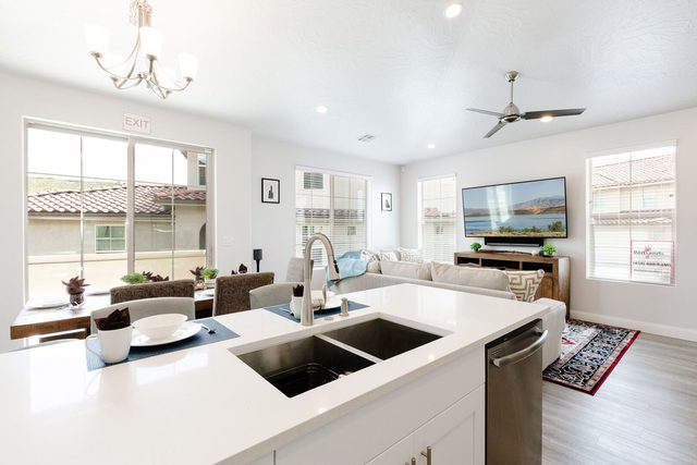 View across the kitchen sink toward dining and living areas