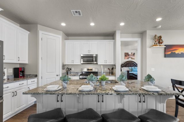 Kitchen island with granite counters and bar stools