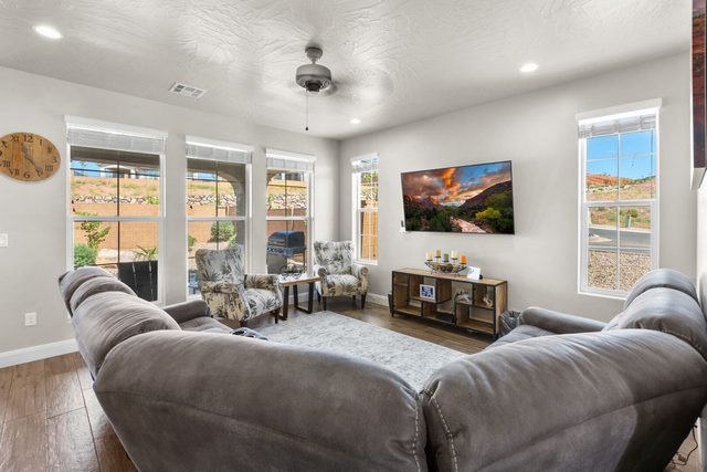 Living room with gray sectional, armchairs and smart TV