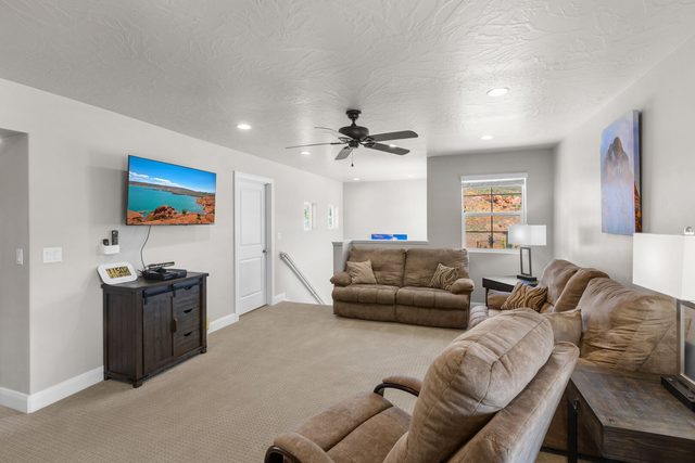 Upstairs family room with reclining seating and wall TV
