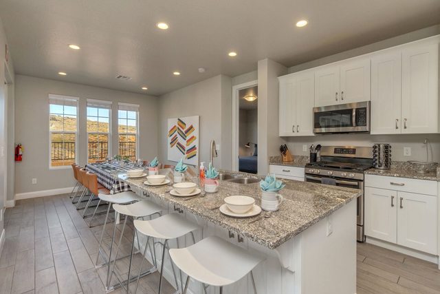 Kitchen island with bar stools and white cabinetry