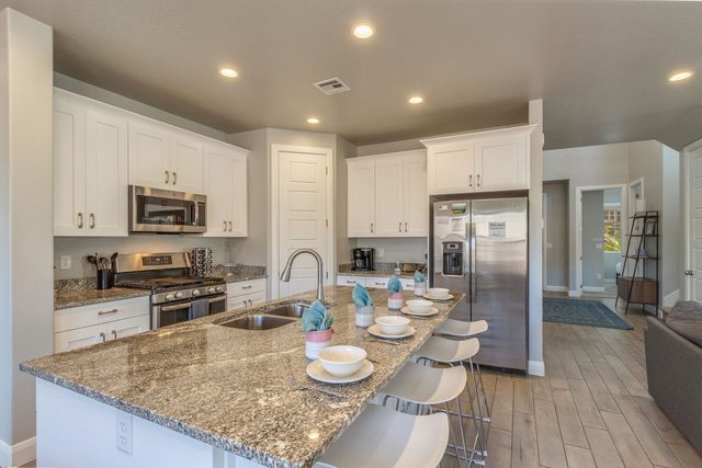Kitchen with granite island, stainless appliances and bar seating