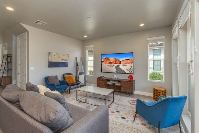 Bright great room with gray sofa and large windows