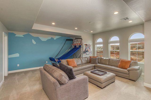 Upstairs loft with sectional sofa and basketball arcade
