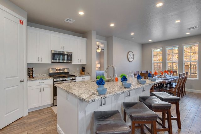 White kitchen with granite island and bar stool seating