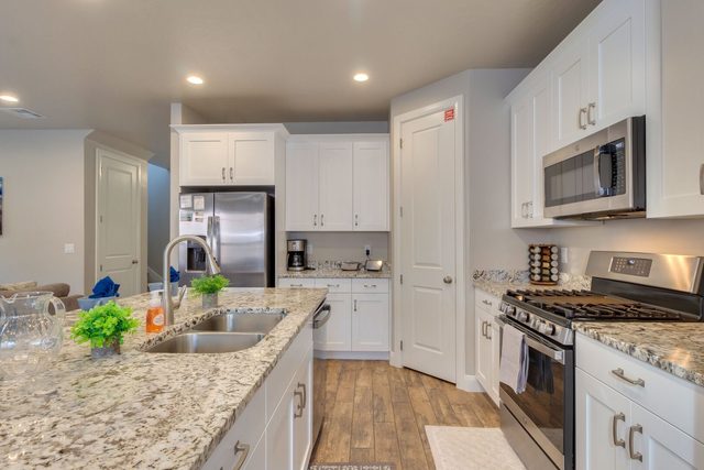 Kitchen with gas range, stainless refrigerator and granite counters
