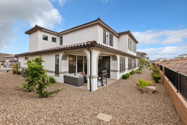 Rear exterior of Escondido 2311 with covered patio and gravel yard
