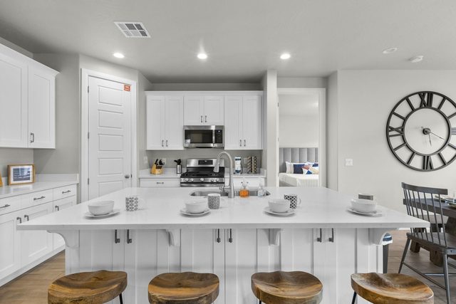 Kitchen island with bar stools for four and white cabinets