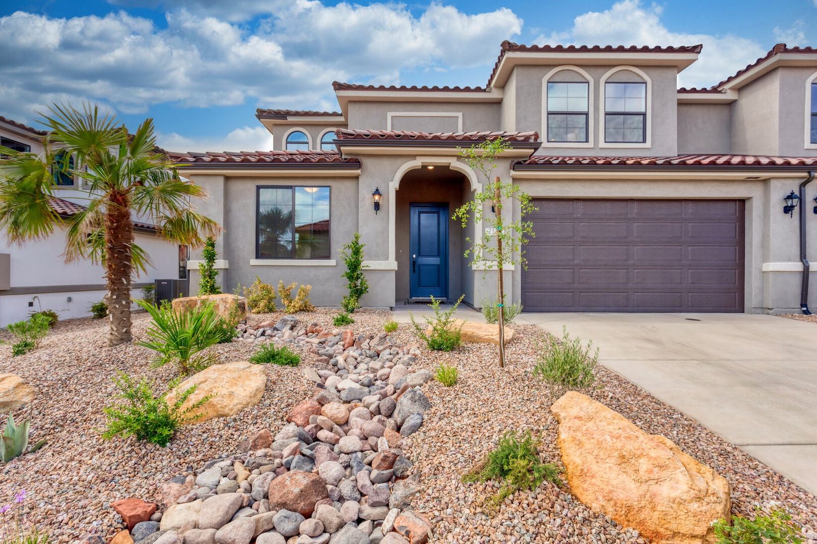 Two-story stucco front of Escondido 2323 with tile roof and two-car garage