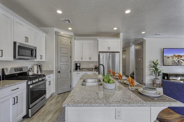 Kitchen with gas range, stainless appliances and granite island