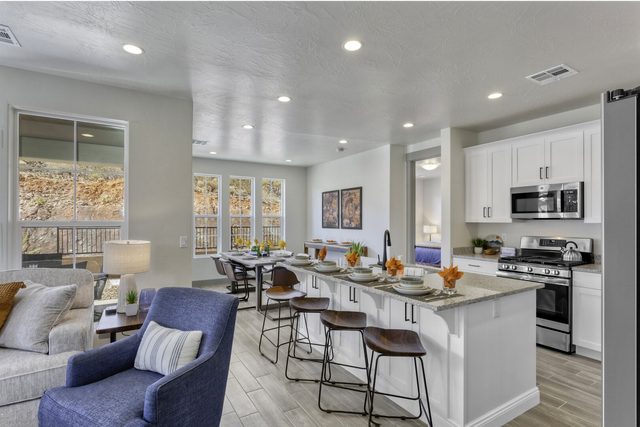 Open great room flowing into kitchen island with bar stools