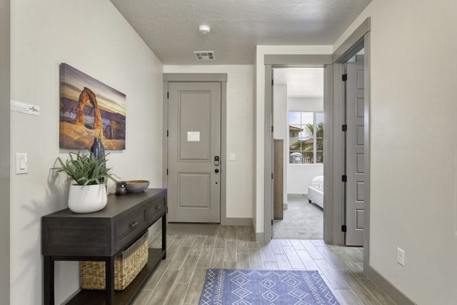 Front entry hallway with console table leading to a downstairs bedroom
