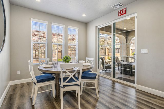Round dining table with white chairs next to patio doors in 2355