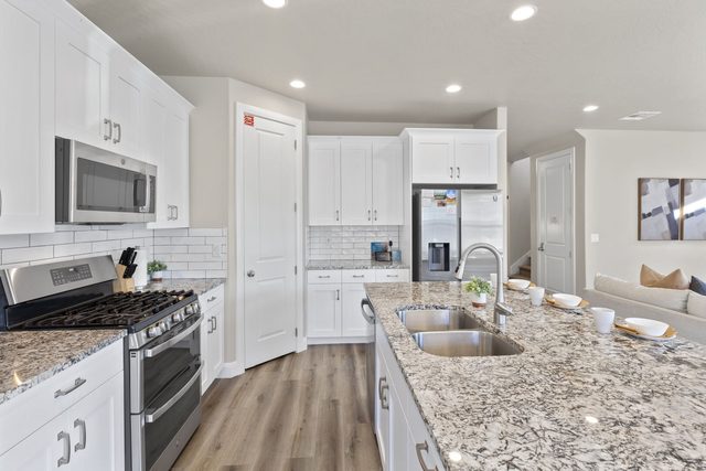 Kitchen with gas range, stainless appliances and granite counters