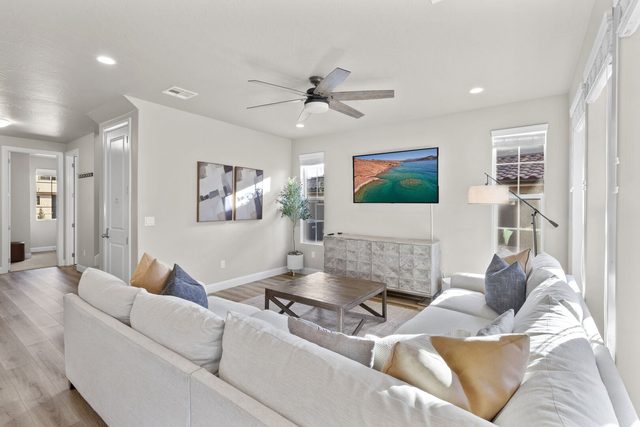 Great room sectional with windows and hallway to the entry