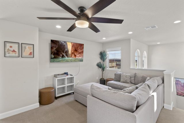 Upstairs loft with gray sectional and wall-mounted TV