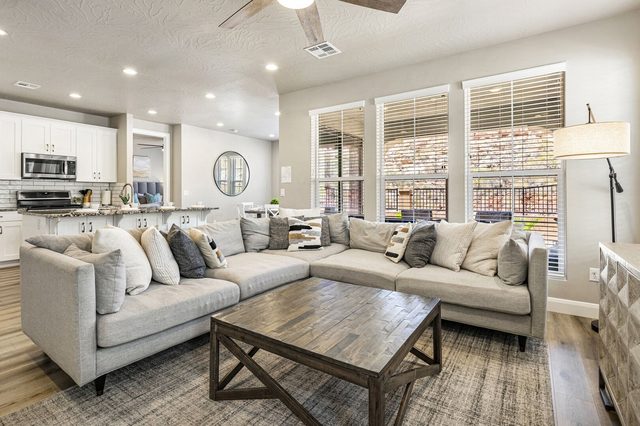 Great room sectional sofa with kitchen and windows behind