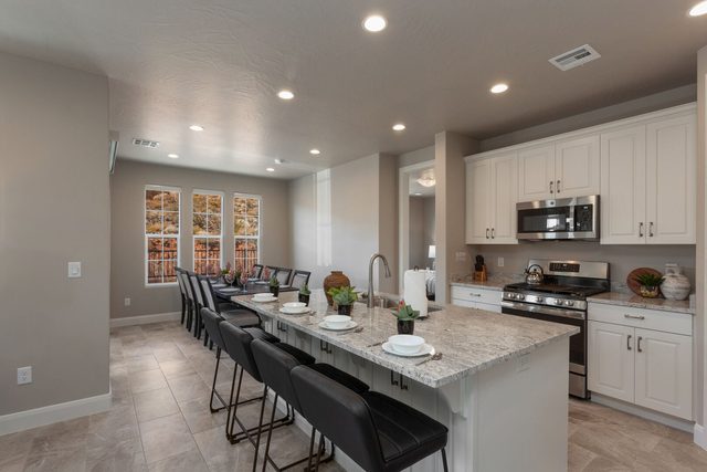 Long granite kitchen island with bar stools and dining table