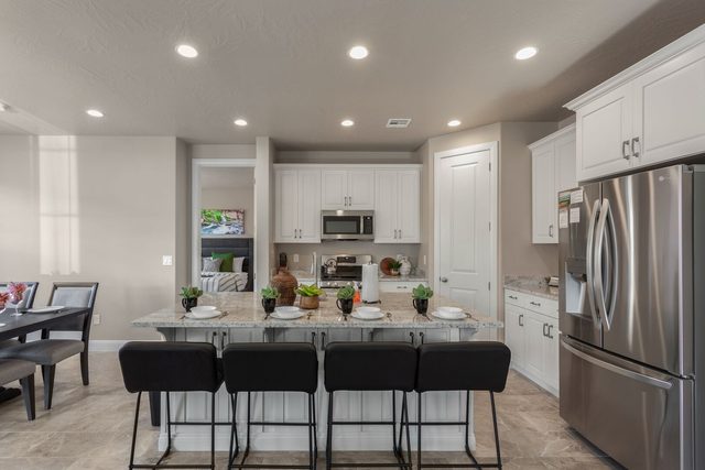 Kitchen island seating for five facing white cabinets