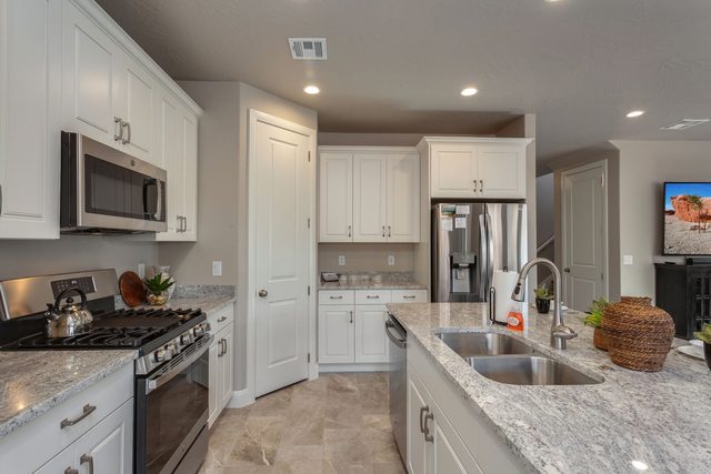 Kitchen with gas range, double sink and stainless fridge