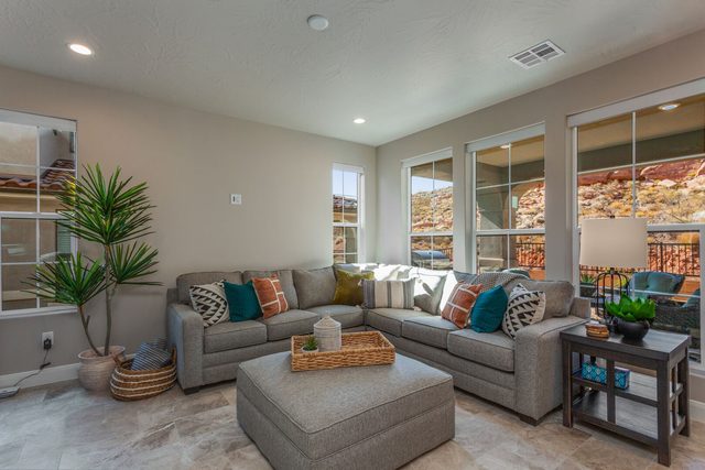 Living room sectional with ottoman and red rock window views