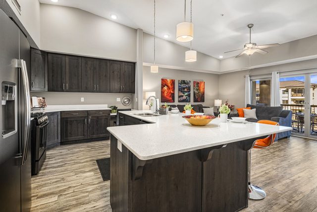 Kitchen island with quartz counter and dark wood cabinets