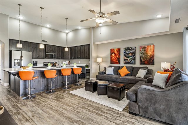 Open living room and kitchen with orange bar stools at Estancia 306 W