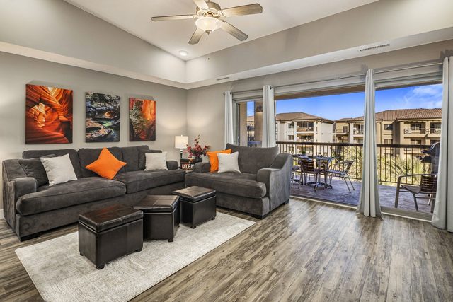Living room sofas with red rock art and balcony access