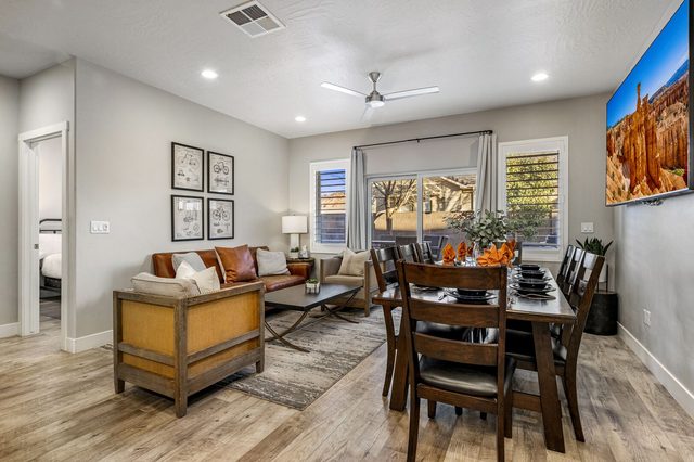 Living room and dining table under a large wall TV