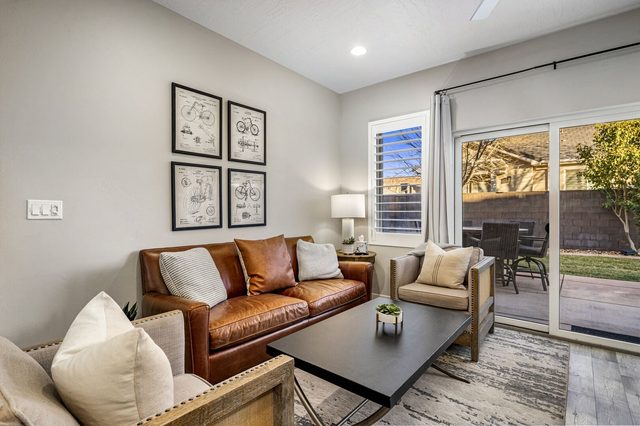 Living room with leather sofa beside patio sliding doors