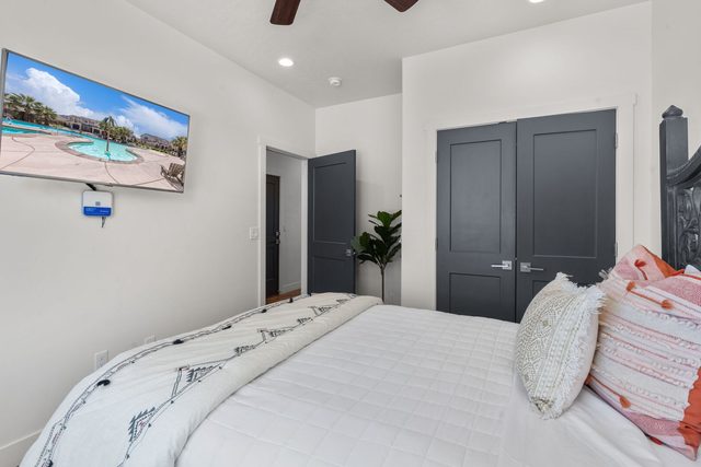 Queen bedroom with wall TV and closet doors