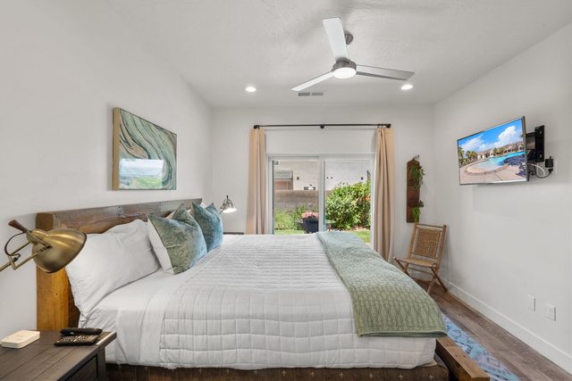 Main-floor king bedroom with wood headboard and patio door