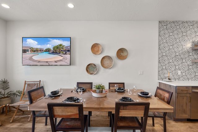 Wood dining table with place settings beneath woven wall baskets