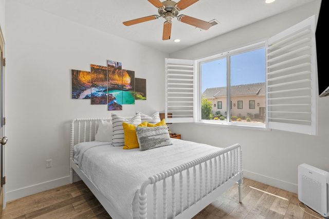 Queen bedroom with white spindle bed and window shutters
