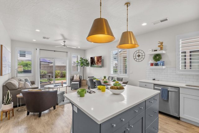 Kitchen island with gold pendant lights beside the living room