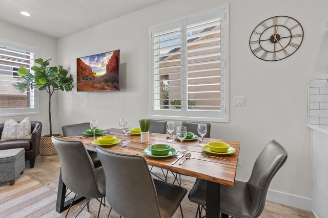 Dining table for six with place settings and wall TV