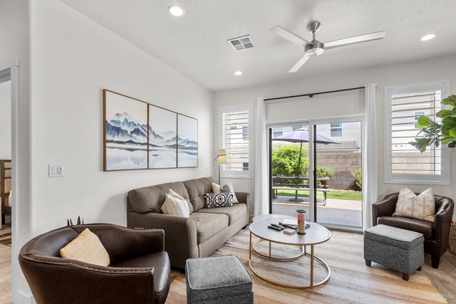 Living room with sofa, leather armchairs and sliding patio door